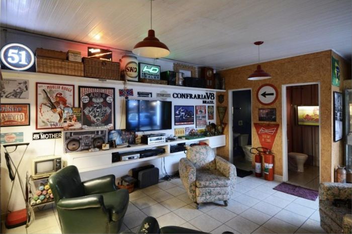 Sala de estar com o letreiro Confraria V8 na parede